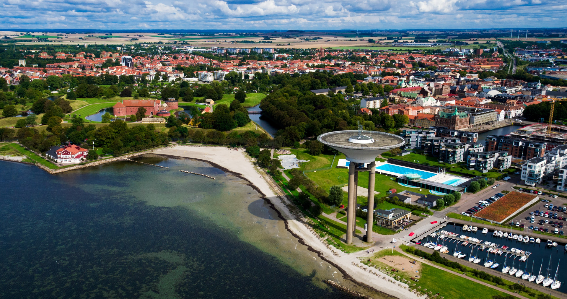 Flygbild över Landskrona med Citadellet, vattentornet, badhuset och hamnen - här ligger XoExtensions salong.